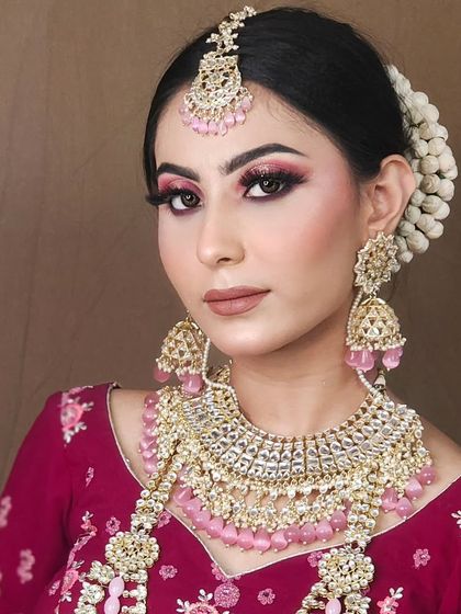 A complete bridal set featuring a beautiful choker, matching jhumkas, and maang tikka with delicate pink bead drops. This set is perfect for pairing with pastel or pink-toned lehengas.