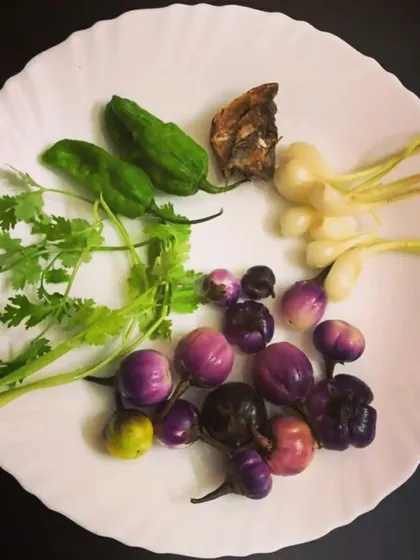 The secret to my authentic Naga dishes lies in the ingredients. This plate shows fresh Naga Lehsun, fiery King Chilly, unique Titaguti (bitter tomato), and pungent Ngari (fermented fish), ready for today's lunch.