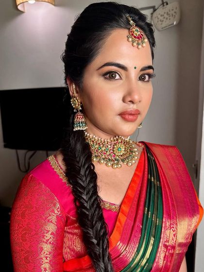 A beautiful look with a fishtail braid. The makeup is kept soft and glowing, with a warm lip color that complements her multi-toned silk saree.