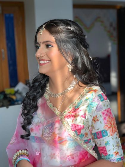Haldi bride Manisha, glowing in the sun. Her makeup has a pop of color on the eyes to match her vibrant outfit.