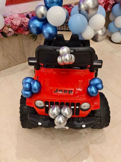 A fun detail for the birthday boy's entrance: his toy jeep decorated with matching blue and silver balloons.