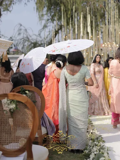 Guests using the elegant white umbrellas, which add to the overall aesthetic of the event.
