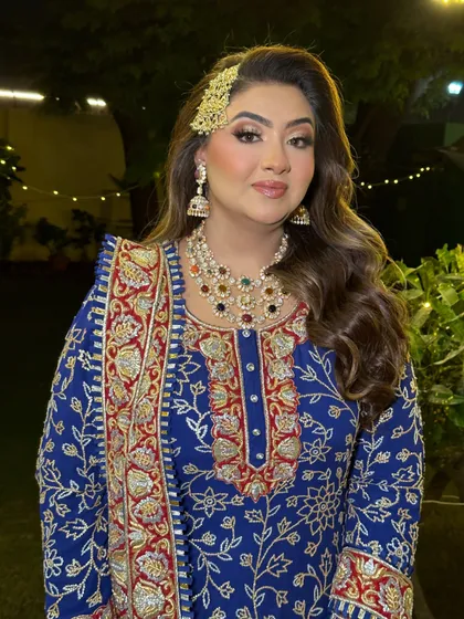 A regal look for a Sufi Night. The makeup features a classic smokey eye and a nude lip, paired with a side-swept hairstyle and a traditional passa.