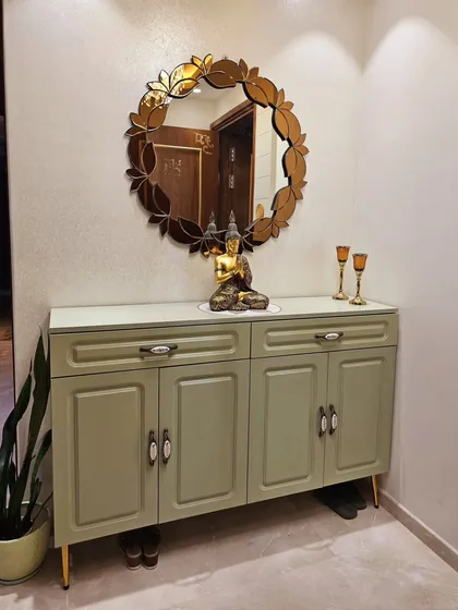 Storage can be beautiful. I designed this elegant console unit in a sage green PU finish to discreetly hide shoes, keeping the entryway organized and stylish for my client, Mrs. Rachana Agarwal.