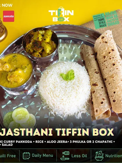 Experience the flavors of Rajasthan with our Rajasthani Tiffin Box. It includes a unique Rajdhani Curry Pakkoda, Aloo Jeera, Dal Fry, rice, salad, and phulkas.