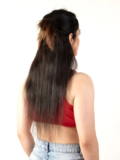 A back view of a model with a half-up hairstyle using extensions.