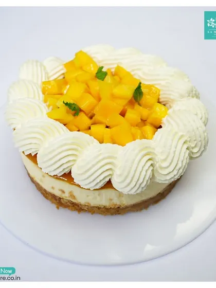 Another angle of our Mango Cheesecake, showing the generous topping of fresh, diced mango nestled in a ring of whipped cream.