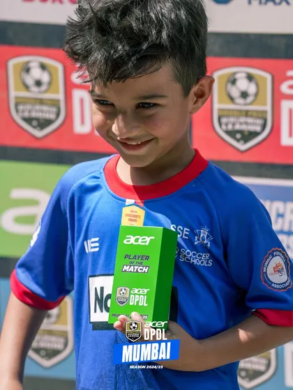 A young player from our U7-U9 age group proudly holding his Player of the Match award from the DPDL league.