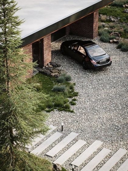 An aerial perspective of the property, showing the relationship between the garage, driveway, and natural landscape. This type of shot is crucial for understanding the layout and scale of a project.
