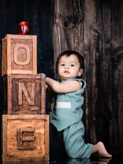 Another angle of the first birthday shoot with wooden "ONE" blocks and a rustic theme.