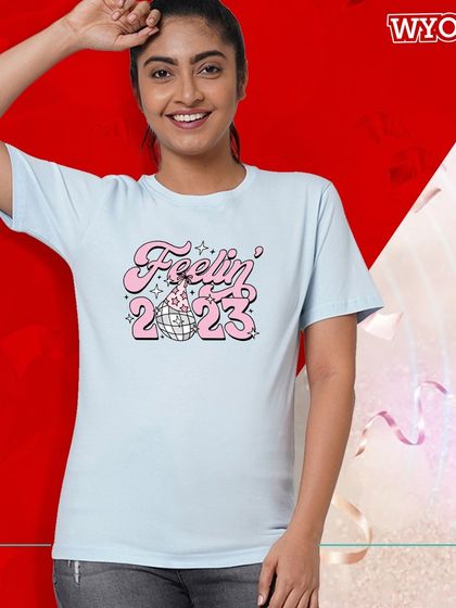 "Feelin' 2023." A cute and trendy t-shirt design to wear for your New Year's Eve party, featuring a retro font and disco ball.