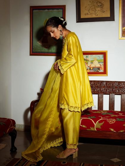 An elegant portrait for Baavli, showing the beautiful drape and flow of a yellow silk ensemble.