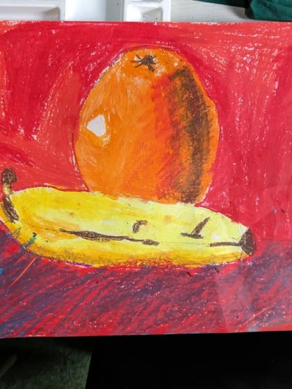 A bold and expressive still life of an orange and a banana. This student used oil pastels with strong strokes to create a textured and vibrant artwork.