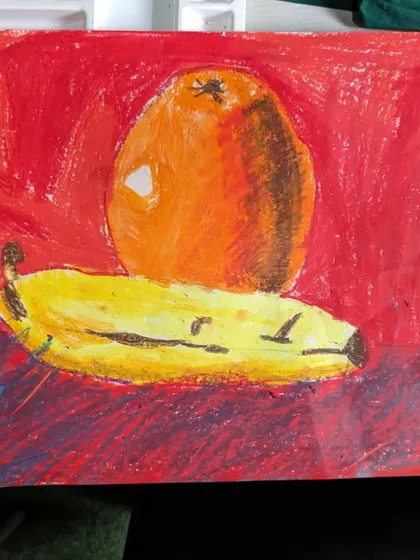 A bold and expressive still life of an orange and a banana. This student used oil pastels with strong strokes to create a textured and vibrant artwork.
