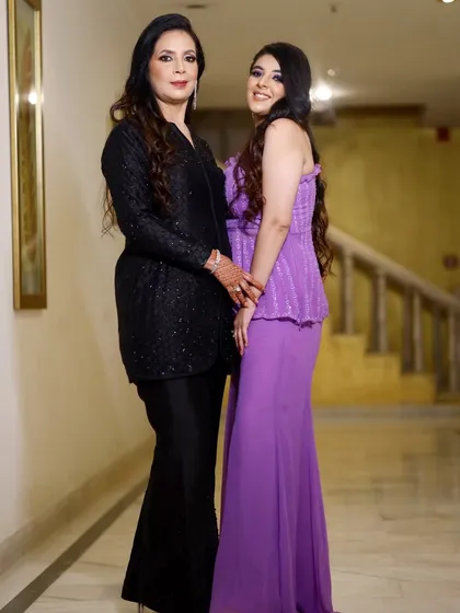 An elegant portrait of two women, possibly a mother and daughter, posing in a classic indoor setting. These are timeless photos from any family function.