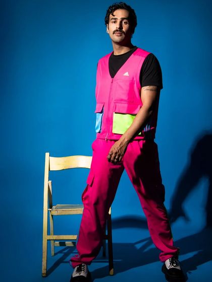 A strong, standing pose that gives a clear view of the entire outfit. The simple prop adds a point of interest without being distracting.