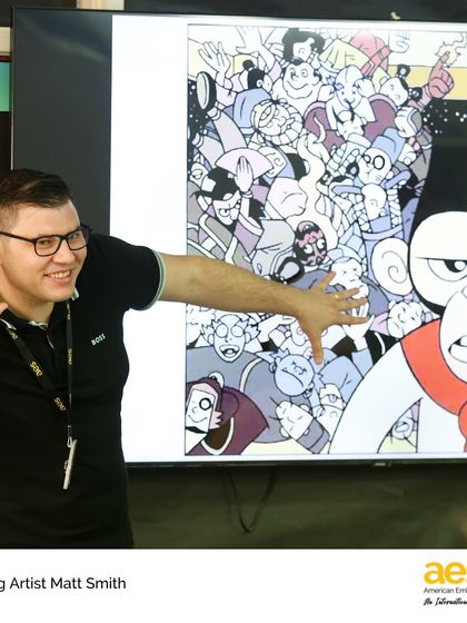 Cartoonist Matt Smith explains a concept using one of his own vibrant comics. Bringing artists to campus provides a unique window into the creative process and the world of visual arts.