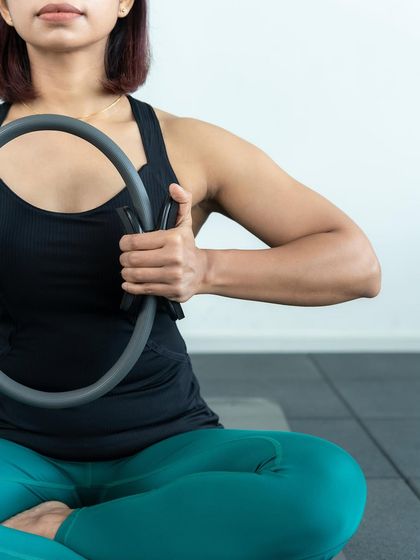 The Magic Circle is a versatile prop that adds resistance to mat exercises. Here, it's used to engage the inner thighs and deepen the core connection.