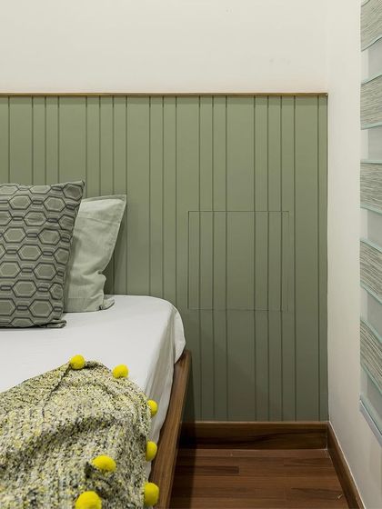 A detail shot of the minimalist bedroom, showing the clean lines of the wall paneling and the clever, concealed bedside niche before it's opened.