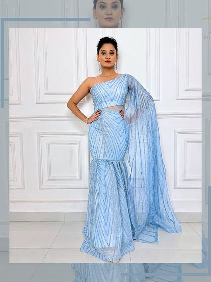 A full view of the one-shoulder ice-blue gown, showcasing its unique mermaid-style silhouette and sparkling fabric.