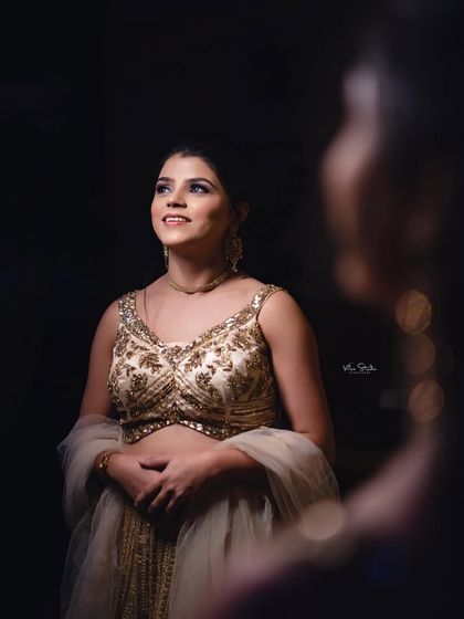 A creative shot of the bride looking at her reflection. This "getting ready" photo has a thoughtful and elegant feel, capturing a moment of anticipation.