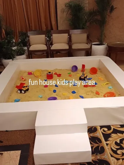 A close-up of the sandpit filled with 100% kinetic sand and a variety of colorful toys, ready for a sensory adventure.