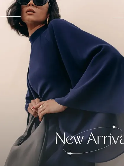 A detailed shot of the Armani dress, focusing on the dramatic shape of the sleeves and the high-quality banana crepe fabric.