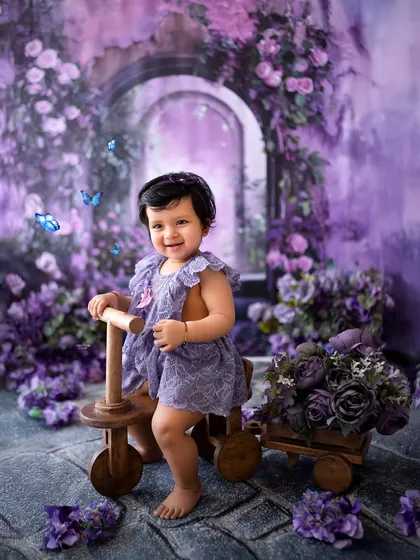 Ready for an adventure on her wooden tricycle through a field of purple flowers.