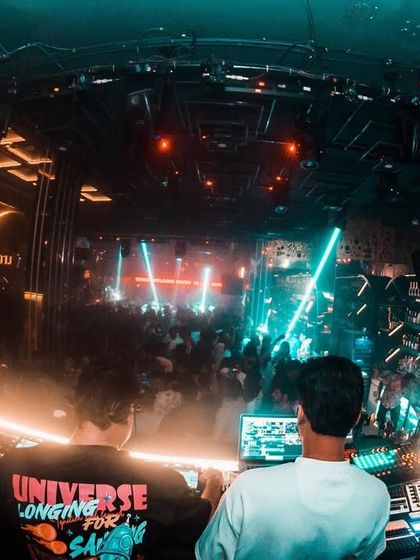 A look from the DJ booth at Club LITT, showing the complex lighting and the crowd below.