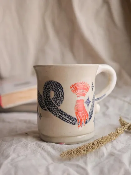 The 'Slithering Time' mug. I used the sgraffito technique on this piece, carving through a layer of color to reveal the clay body underneath. It creates such a beautiful, illustrative effect.