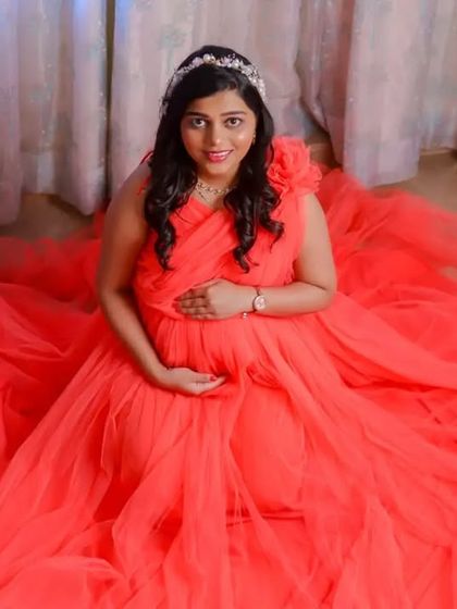 Our coral net gown is incredibly versatile. These studio shots show how it can be styled for elegant, seated portraits, with the fabric creating a soft pool of color.