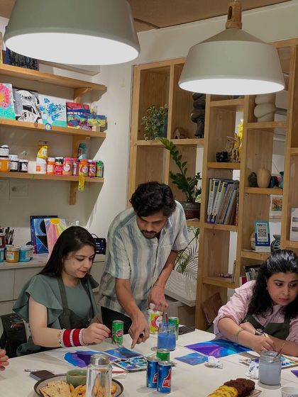 An instructor provides one-on-one guidance during a painting workshop. We make sure everyone feels supported on their creative journey, no matter their skill level.