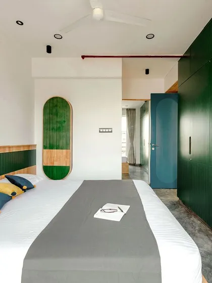 The full view of the T7 T8 master bedroom, showing how the green wardrobes and wall art create a cohesive and calming design.