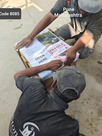Our team works together to finalize the packing of a crate destined for Pune, ensuring all labels and instructions are correctly placed.