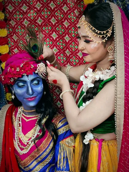 A candid moment from the shoot, showing Radha adjusting Krishna's headpiece. This highlights the detailed accessories that complete the character transformations.