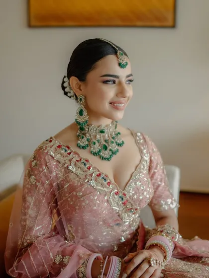 Pretty in pastels. This bride’s look was all about soft, romantic elegance. We used a palette of pinks and a dewy base to create a fresh, glowing look that complemented her stunning pastel lehenga and emerald jewelry.
