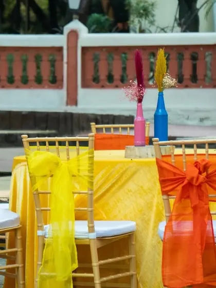 A closer look at the guest seating, with vibrant yellow and orange tablecloths and matching chair decor, creating a cheerful dining atmosphere.