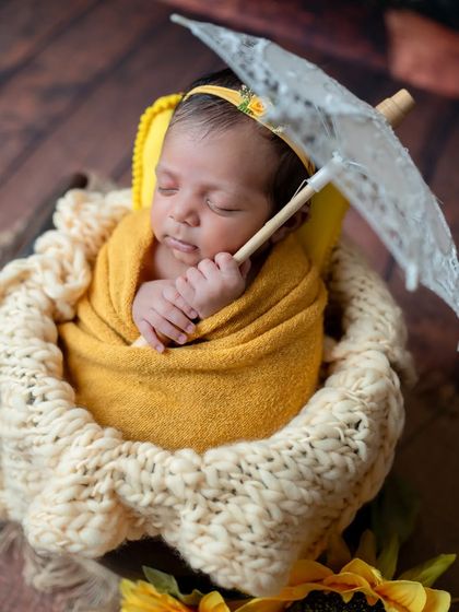 Adding a tiny prop like this lace umbrella can bring a touch of whimsy and charm to a classic basket pose.