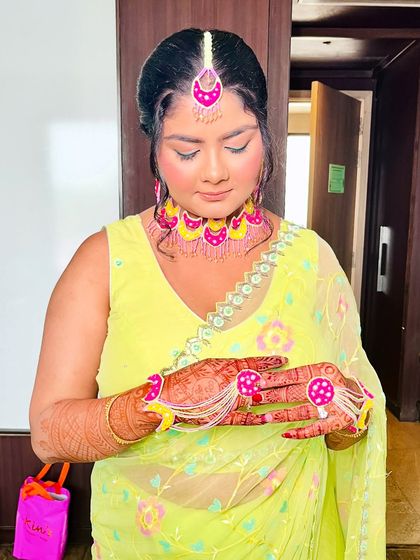 A close-up of the bride's hands, adorned with beautiful henna and floral jewelry, completing her Haldi look.