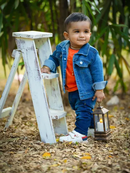 This little guy looks so cool and confident during his outdoor session. The denim jacket and lantern prop add a rustic, adventurous feel.