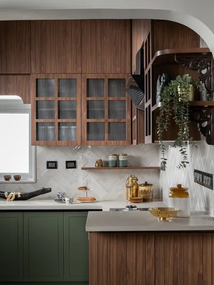 This kitchen proves that functional spaces can also be the most beautiful. I paired rich olive green cabinetry with warm wood tones and fluted glass to create a modern-traditional feel. The gentle archway and carved wooden brackets are details that add a layer of handcrafted charm, making the everyday act of cooking feel special.