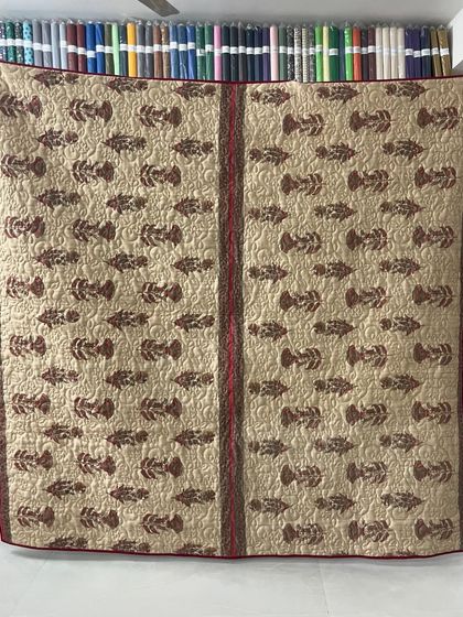 A full view of a memory quilt made from a mother's sarees, featuring a lovely fish-block print.