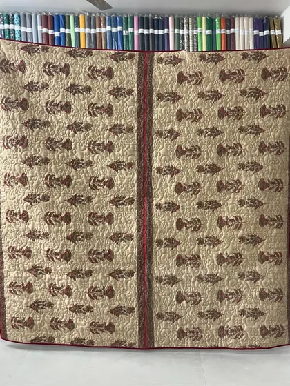 A full view of a memory quilt made from a mother's sarees, featuring a lovely fish-block print.