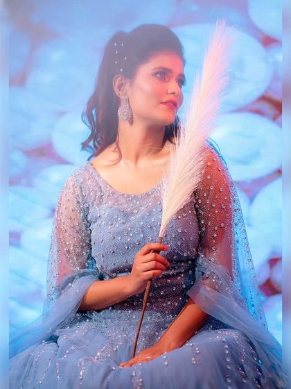 A whimsical portrait in a sparkling blue gown. The soft lighting and feather prop add to the fairytale feel of this beautiful dress.