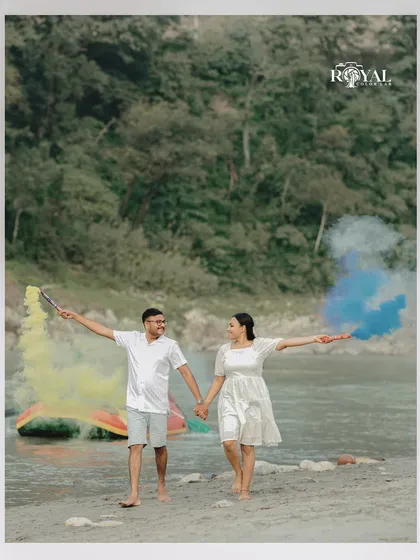 A vibrant shot of a couple walking on the beach holding colorful smoke sticks, adding a splash of fun to their shoot.