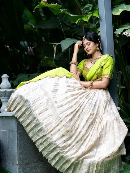 Wrapped in elegance, this half saree features a light gold tissue lehenga paired with a vibrant lime green princess katori blouse. The entire ensemble, including the dupatta, is finished with intricate handwork for a look of traditional grace.
