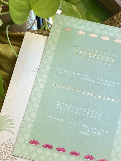 The reception card from the suite, showing the beautiful combination of mint green paper, gold foil text, and a subtle lotus motif border.
