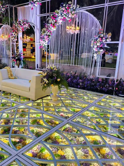 An absolutely stunning reception stage featuring one of my signature offerings: a glass floor filled with a bed of illuminated flowers. It creates an ethereal, magical effect that makes the couple feel like they are walking on air.