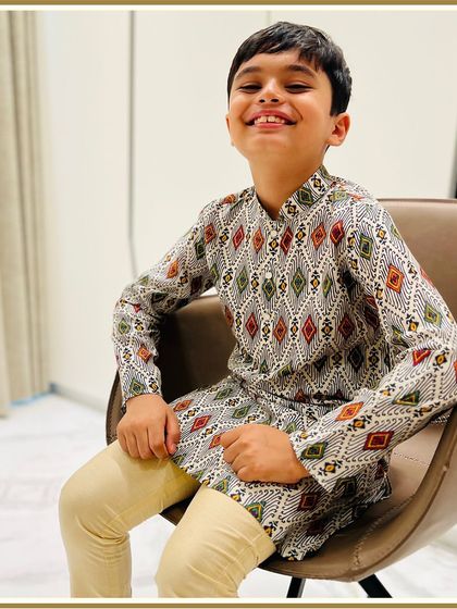 A happy client sitting comfortably in our store, looking stylish in a printed kurta. We love helping you find the perfect traditional wear for your kiddo.
