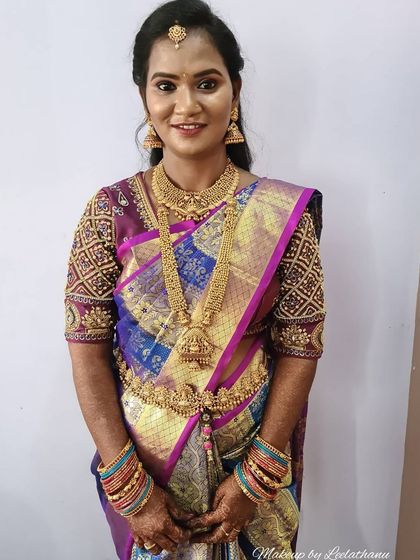 This client is ready for her reception. This phone photo shows a classic look with a beautiful multi-toned silk saree, traditional gold jewelry, and a hairstyle of soft curls.